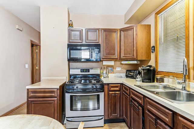 1304 S 50th Ave, Cicero, IL 60804 - kitchen with black microwave, stainless steel gas stove, light countertops, and light wood-type flooring