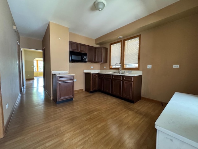 1304 S 50th Ave, Cicero, IL 60804 - kitchen with black microwave, light wood-style floors, light countertops, and dark brown cabinetry