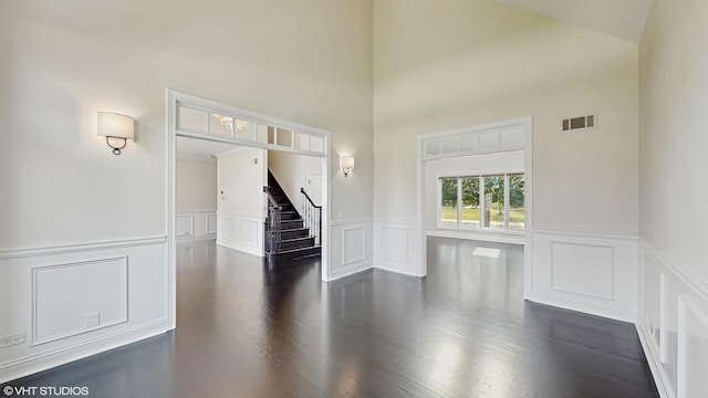 392 Spruce Rd, Wood Dale, IL 60191 - foyer featuring a wainscoted wall, a decorative wall, stairway, dark wood-style floors, and a towering ceiling