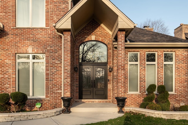 392 Spruce Rd, Wood Dale, IL 60191 - view of exterior entry with brick siding, french doors, a chimney, and roof with shingles