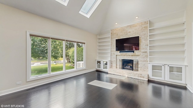 392 Spruce Rd, Wood Dale, IL 60191 - unfurnished living room featuring built in features, wood finished floors, a skylight, a fireplace, and high vaulted ceiling