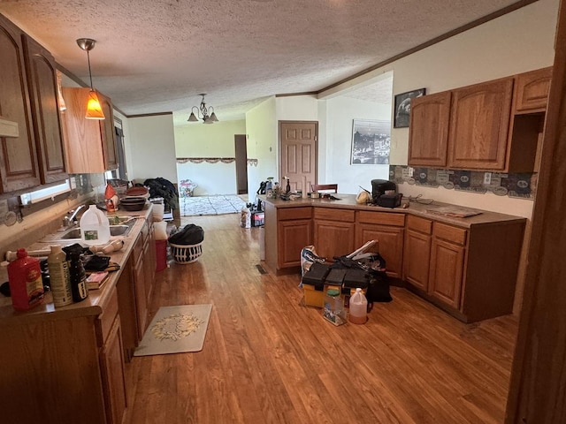810 Harding Ave, Gillespie, IL 62033 - kitchen with light wood-style floors, a textured ceiling, lofted ceiling, brown cabinetry, and a peninsula