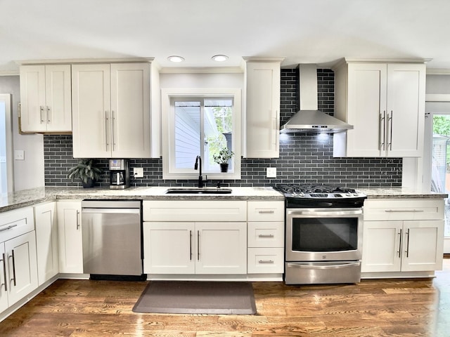 120 Walter Ct, Bloomingdale, IL 60108 - kitchen featuring appliances with stainless steel finishes, wall chimney exhaust hood, ornamental molding, backsplash, and light stone countertops