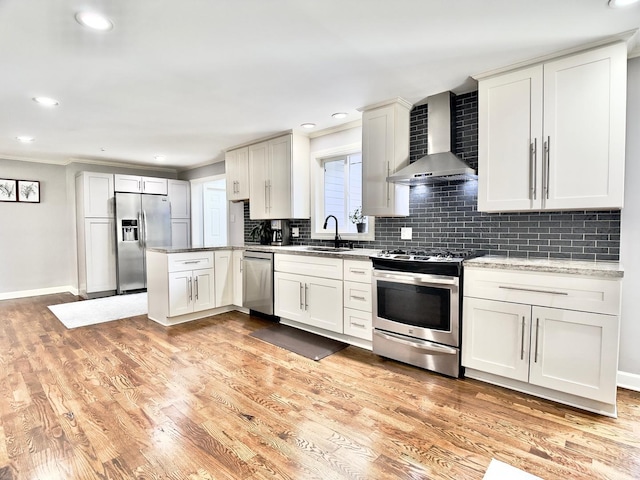 120 Walter Ct, Bloomingdale, IL 60108 - kitchen with appliances with stainless steel finishes, wall chimney exhaust hood, decorative backsplash, a peninsula, and light wood finished floors