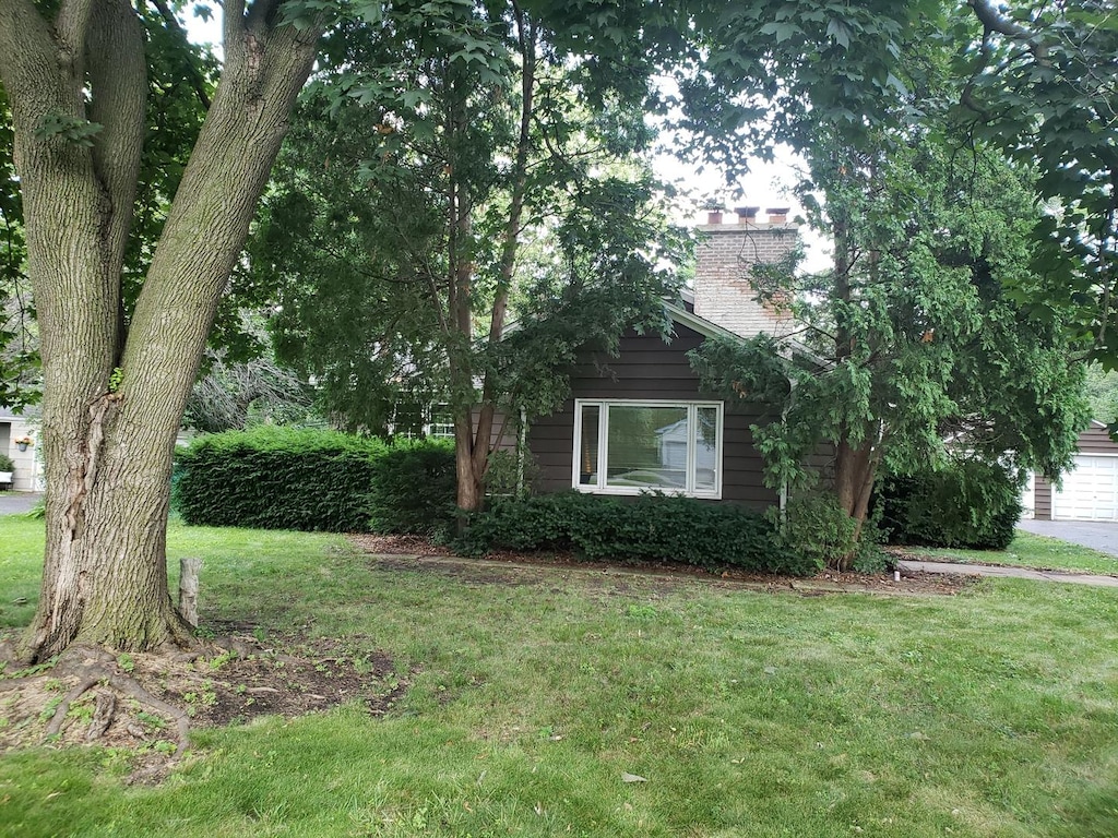 615 Polo Dr, Wheaton, IL 60187 - view of front of house with a front yard, a chimney, and a garage