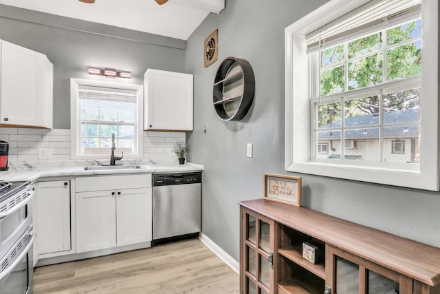 41607 N Lotus Ave, Antioch, IL 60002 - kitchen featuring stainless steel appliances, tasteful backsplash, vaulted ceiling, light wood finished floors, and white cabinets