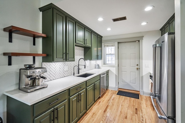 1654 W Berwyn Ave Unit 2W, Chicago, IL 60640 - kitchen featuring appliances with stainless steel finishes, green cabinets, open shelves, light wood finished floors, and backsplash