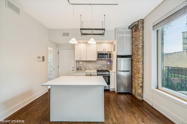 1407 N Wells St Unit 3E, Chicago, IL 60610 - kitchen with stainless steel appliances, backsplash, dark wood-style floors, a center island, and light countertops
