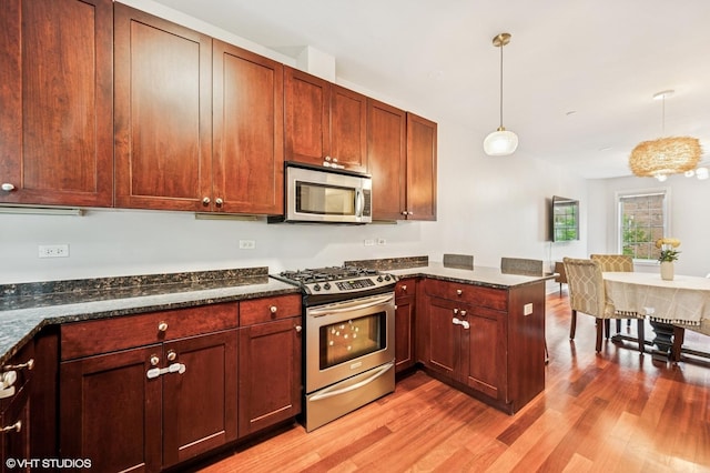 1657 Church St, Evanston, IL 60201 - kitchen with appliances with stainless steel finishes, a peninsula, light wood-type flooring, and hanging light fixtures