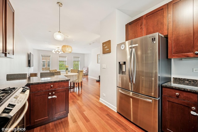 1657 Church St, Evanston, IL 60201 - kitchen featuring stainless steel appliances, light wood-style flooring, a chandelier, and dark stone counters