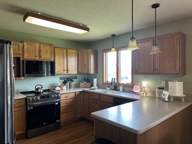 15459 Henry Rd Unit A, Morrison, IL 61270 - kitchen with stainless steel appliances, a peninsula, pendant lighting, dark wood-style floors, and light countertops