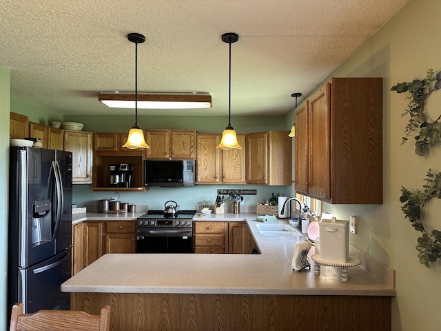 15459 Henry Rd Unit A, Morrison, IL 61270 - kitchen with black appliances, a peninsula, a textured ceiling, light countertops, and pendant lighting