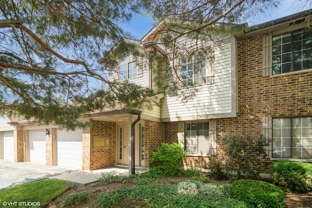 4130 N Pheasant Trail Ct Unit 2, Arlington Heights, IL 60004 - view of front of house with brick siding, driveway, and a garage