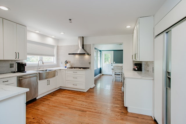 974 Webster Ln, Des Plaines, IL 60016 - kitchen with stainless steel dishwasher, wall chimney exhaust hood, tasteful backsplash, light stone counters, and white cabinetry