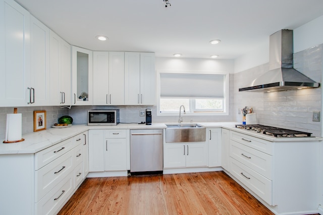 974 Webster Ln, Des Plaines, IL 60016 - kitchen with appliances with stainless steel finishes, wall chimney exhaust hood, decorative backsplash, glass insert cabinets, and recessed lighting