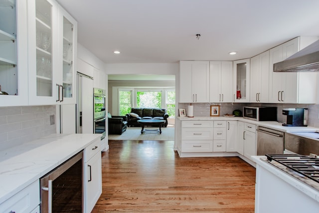 974 Webster Ln, Des Plaines, IL 60016 - kitchen with beverage cooler, stainless steel appliances, tasteful backsplash, light wood-type flooring, and white cabinets