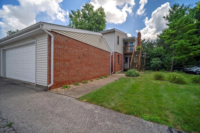 903 N Linden St Unit 131, Normal, IL 61761 - view of side of property featuring brick siding, a yard, an attached garage, stairway, and asphalt driveway