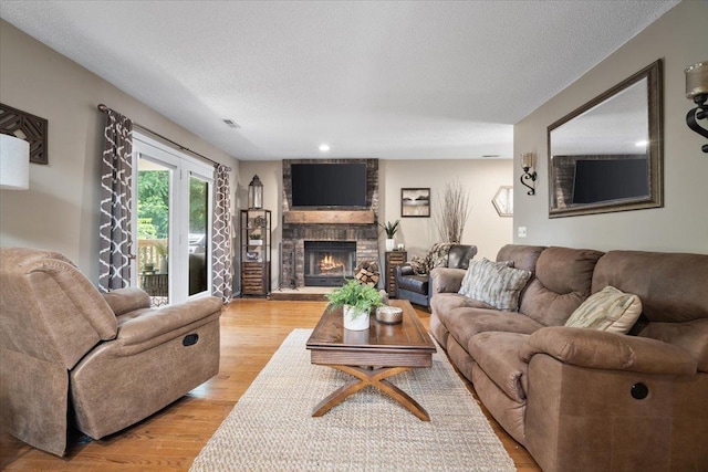 903 N Linden St Unit 131, Normal, IL 61761 - living area featuring a brick fireplace, light wood-style flooring, and a textured ceiling