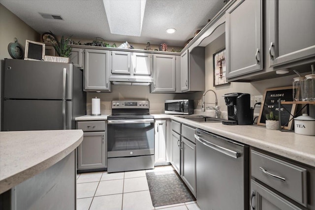 903 N Linden St Unit 131, Normal, IL 61761 - kitchen featuring stainless steel appliances, gray cabinets, a textured ceiling, and under cabinet range hood