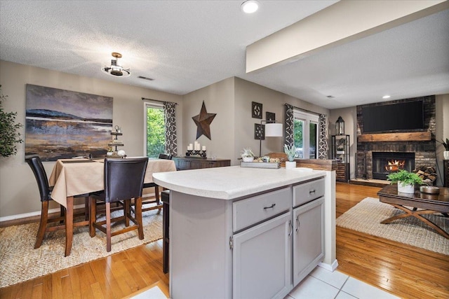 903 N Linden St Unit 131, Normal, IL 61761 - kitchen with open floor plan, a fireplace, a kitchen island, light countertops, and a textured ceiling