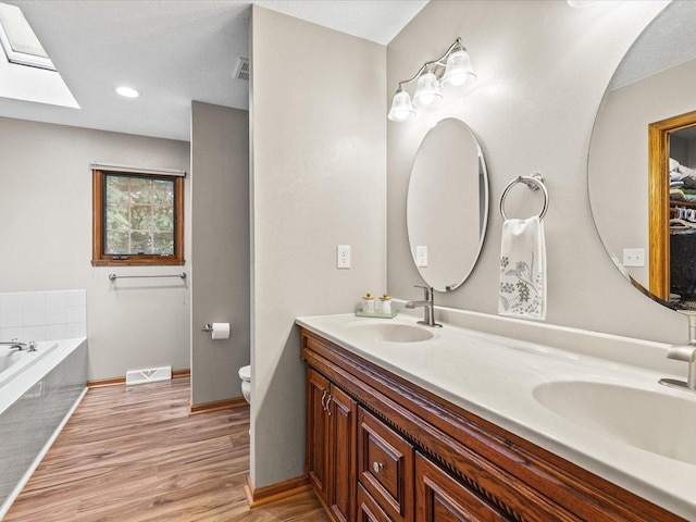 316 Harwich Pl, Rockton, IL 61072 - full bath featuring a skylight, wood finished floors, double vanity, a bath, and recessed lighting
