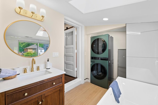 605 Home Ave, Oak Park, IL 60304 - laundry area featuring stacked washer / drying machine, light wood-style flooring, a barn door, and recessed lighting