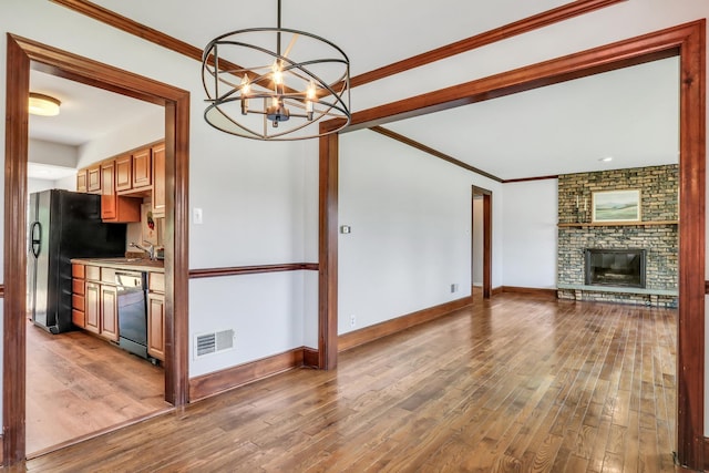 26435 N US Highway 45, Mundelein, IL 60060 - unfurnished living room featuring hardwood / wood-style flooring, a chandelier, a fireplace, and crown molding