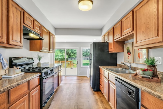26435 N US Highway 45, Mundelein, IL 60060 - kitchen featuring black appliances, under cabinet range hood, light wood-type flooring, brown cabinetry, and light stone counters