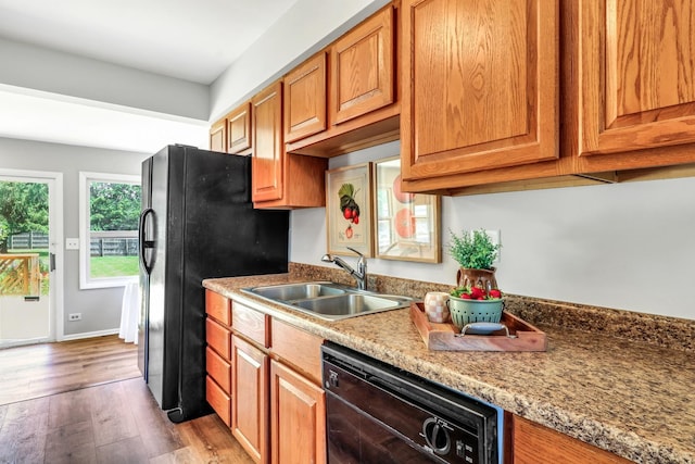 26435 N US Highway 45, Mundelein, IL 60060 - kitchen with black appliances, wood finished floors, brown cabinets, and light stone counters