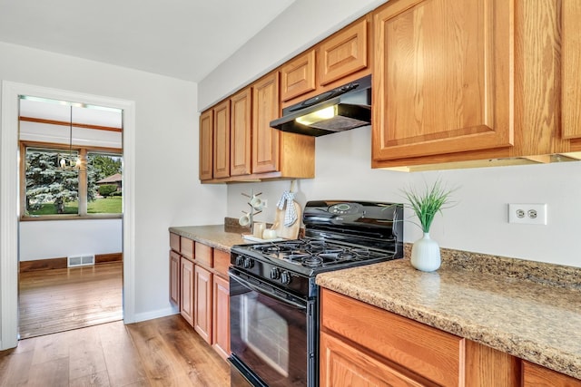 26435 N US Highway 45, Mundelein, IL 60060 - kitchen with gas stove, under cabinet range hood, light wood finished floors, and light stone countertops