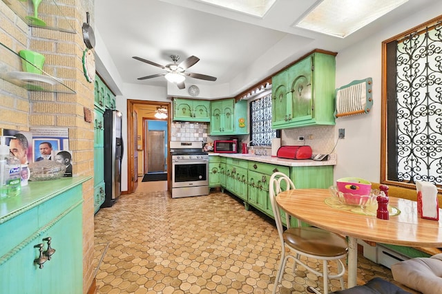 16632 Emerald Ave, Harvey, IL 60426 - kitchen with green cabinetry, stainless steel appliances, tasteful backsplash, light countertops, and a ceiling fan