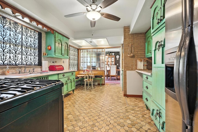 16632 Emerald Ave, Harvey, IL 60426 - kitchen with green cabinets, stainless steel fridge with ice dispenser, light countertops, black gas range oven, and healthy amount of natural light
