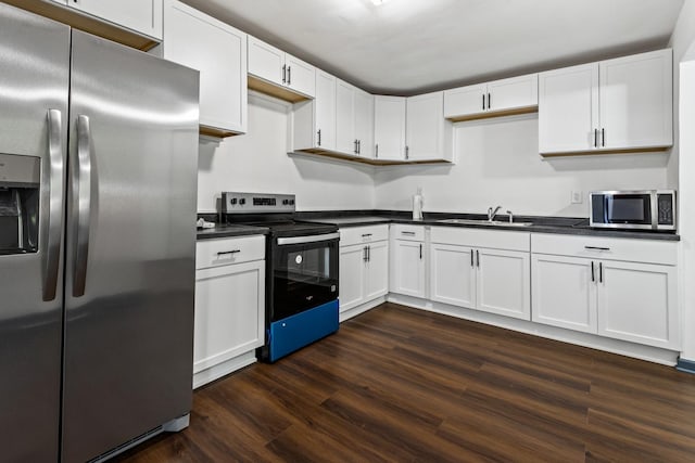 1213 W Fourth St, Dixon, IL 61021 - kitchen with stainless steel appliances, dark countertops, dark wood-style flooring, and white cabinets