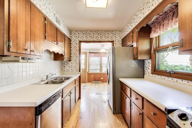 210 N Russel St, Mount Prospect, IL 60056 - kitchen featuring appliances with stainless steel finishes, light wood finished floors, light countertops, brown cabinetry, and wallpapered walls