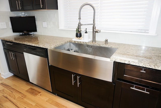 4452 N Newland Ave, Harwood Heights, IL 60706 - kitchen with stainless steel dishwasher, light wood-style flooring, tasteful backsplash, light stone countertops, and dark brown cabinetry