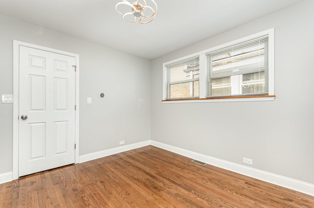 1203 W 110th St, Chicago, IL 60643 - spare room featuring wood finished floors and a chandelier
