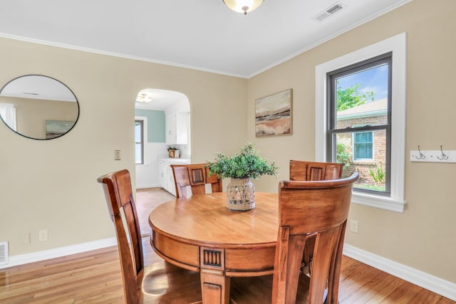 137 School St, Grayslake, IL 60030 - dining area featuring arched walkways, crown molding, light wood finished floors, and plenty of natural light