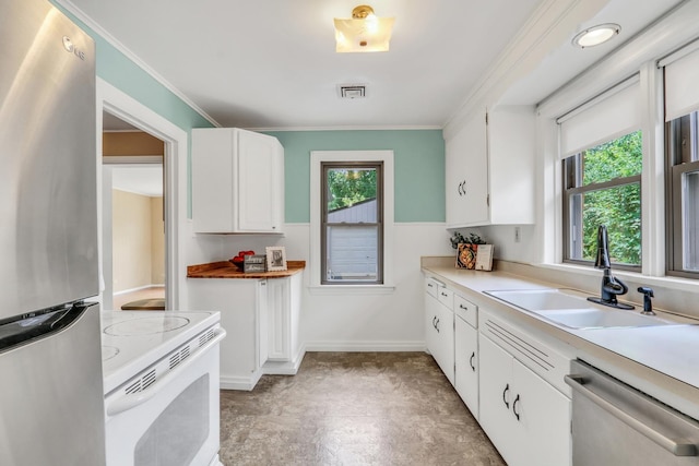 137 School St, Grayslake, IL 60030 - kitchen with appliances with stainless steel finishes, light countertops, white cabinets, and ornamental molding