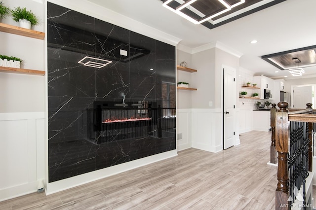 7945 S Avalon Ave, Chicago, IL 60619 - living room featuring light wood-style flooring, a decorative wall, wainscoting, a fireplace, and ornamental molding