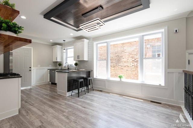 7945 S Avalon Ave, Chicago, IL 60619 - kitchen featuring a decorative wall, appliances with stainless steel finishes, dark countertops, a breakfast bar area, and white cabinetry