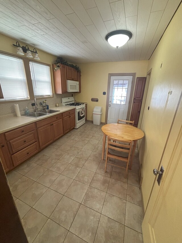 4304 N Oriole Ave, Norridge, IL 60706 - kitchen with white appliances, light countertops, light tile patterned floors, and brown cabinets
