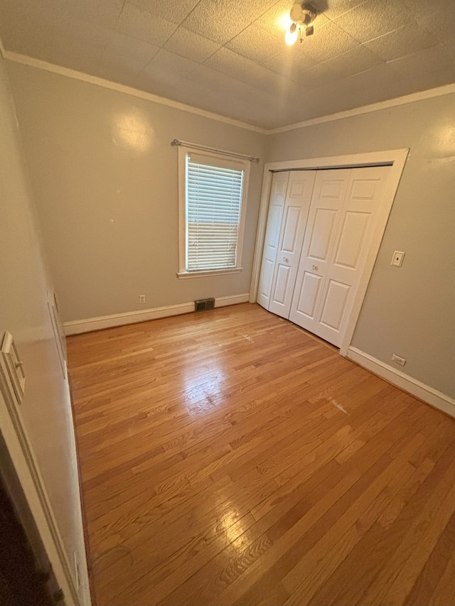 4304 N Oriole Ave, Norridge, IL 60706 - unfurnished bedroom with ornamental molding, light wood-type flooring, and a closet
