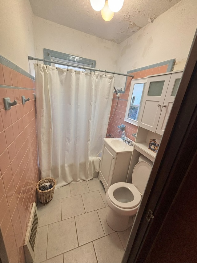 4304 N Oriole Ave, Norridge, IL 60706 - bathroom with tile walls, tile patterned flooring, shower / tub combo, a textured ceiling, and vanity