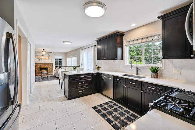 1501 Pine View Ct, Darien, IL 60561 - kitchen with stainless steel appliances, dark cabinetry, decorative backsplash, light countertops, and a peninsula
