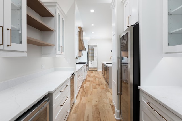 223 Center St, Naperville, IL 60540 - kitchen with freestanding refrigerator, light wood-type flooring, white cabinetry, glass insert cabinets, and recessed lighting