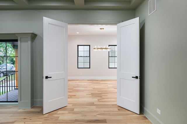 223 Center St, Naperville, IL 60540 - hallway with a chandelier and light wood-style flooring