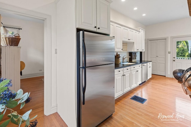 217 N Maple St, Momence, IL 60954 - kitchen with stainless steel appliances, light wood finished floors, white cabinetry, recessed lighting, and backsplash