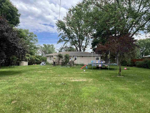 8212 Cameo Dr, Machesney Park, IL 61115 - view of green lawn featuring a trampoline