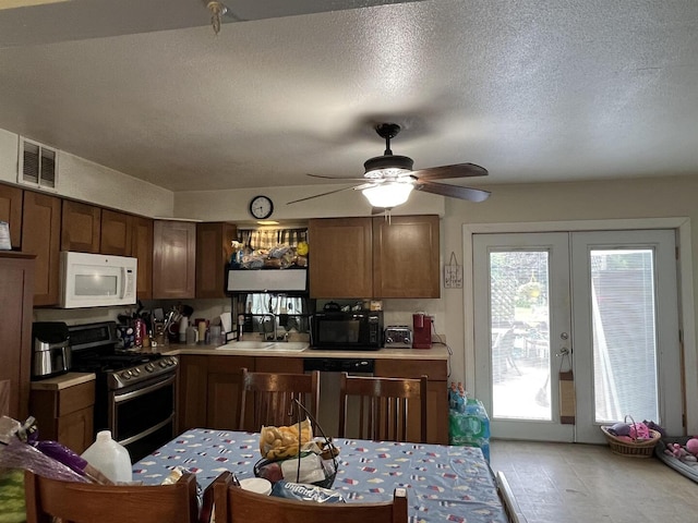 8212 Cameo Dr, Machesney Park, IL 61115 - kitchen with stainless steel appliances, light countertops, ceiling fan, french doors, and a textured ceiling