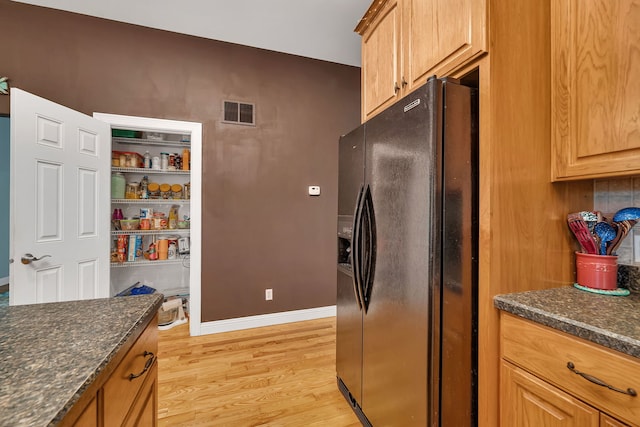 300 Village Ln, Seneca, IL 61360 - kitchen with black fridge with ice dispenser, light wood-style floors, and dark stone counters